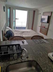 ジョアンペソアにあるBluesunsetのシンクとベッドが備わるホテルルームです。