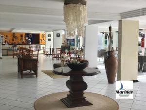 a lobby with a table in the middle of a building at Apart Hotel Marinas Tamandaré in Tamandaré