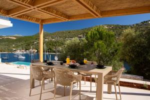 una mesa y sillas en un patio con vistas en Villa Olea-Brand New Luxury Villa, en Sivota