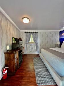 1 dormitorio con 1 cama y TV de pantalla plana en Sunshine Cottage, en Talkeetna