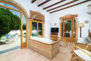 a living room with wicker furniture and a patio at Casa Seniola in Jávea