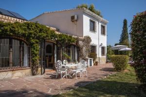 un patio con tavolo e sedie di fronte a una casa di Villa Escocia a Jávea