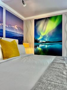 um quarto com uma cama com um mural de parede da aurora boreal em Sunshine Cottage em Talkeetna