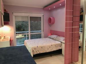 niewielka sypialnia z łóżkiem i oknem w obiekcie Conforto entre a UFSM e o centro w mieście Santa Maria