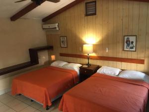 a hotel room with two beds in a room at Hotel La Colonia in Retalhuleu