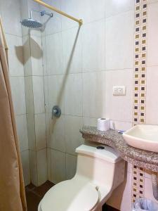 uma casa de banho com um WC e um lavatório em Hostal Tortuga Dorada em Puerto López
