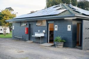 uma casa azul com painéis solares no telhado em Pine Country Caravan Park em Mount Gambier