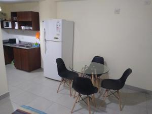 a kitchen with a table and chairs and a refrigerator at Departamento Paseo de los Poetas Premium in Salta