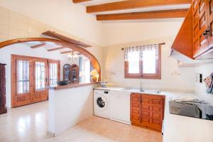 eine Küche mit Waschmaschine und Trockner in der Unterkunft Villa Yvonne - chill out, free WIFI, close to facilities in Benissa