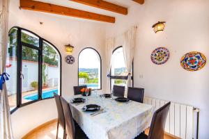 ein Esszimmer mit Tisch und Stühlen und Fenstern in der Unterkunft Villa Yvonne - chill out, free WIFI, close to facilities in Benissa