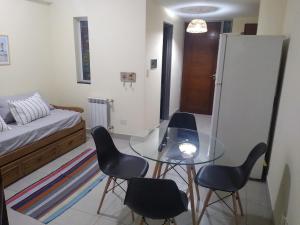 a room with a glass table and chairs and a bed at Departamento Paseo de los Poetas Premium in Salta