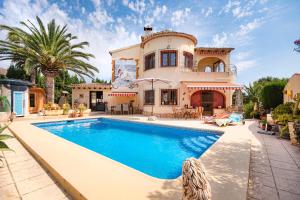 una casa con piscina frente a una casa en Villa Lu, en Benissa