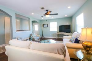 uma sala de estar com dois sofás e uma televisão em PERFECT location spacious yard coffee bar at this lovely beach home em Galveston