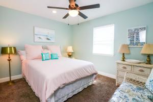 a bedroom with a bed and a ceiling fan at PERFECT location spacious yard coffee bar at this lovely beach home in Galveston