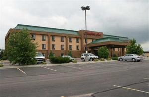 a large building with cars parked in a parking lot at Hampton Inn Mitchell in Mitchell