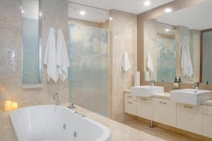a bathroom with two sinks and a bath tub at 241 Santai - Balinese Resort Apartment by uHoliday in Casuarina