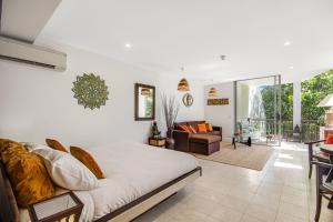a bedroom with a bed and a living room at 241 Santai - Balinese Resort Apartment by uHoliday in Casuarina