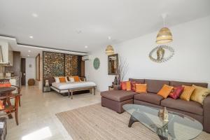 a living room with a couch and a table at 241 Santai - Balinese Resort Apartment by uHoliday in Casuarina +9 photos