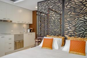 a bedroom with a bed with orange and white pillows at 241 Santai - Balinese Resort Apartment by uHoliday in Casuarina