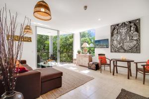 a living room with a couch and a table at 241 Santai - Balinese Resort Apartment by uHoliday in Casuarina