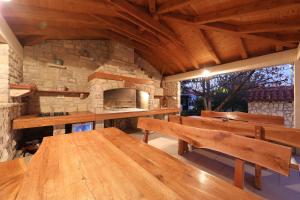 una sala da pranzo con tavoli in legno e un forno in pietra di Apartments BoBo a Kraj