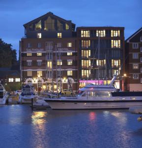 um barco ancorado na água em frente a um edifício em Salthouse Harbour Hotel em Ipswich