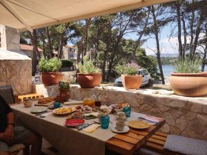 una mesa con comida y vistas al agua en Stone Villa Hvar Ana and Nikola Beachfront en Jelsa