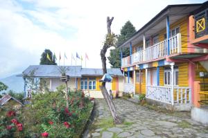 una casa amarilla con un tronco de árbol delante de ella en Rishop - Zivaan Stay en Rishop