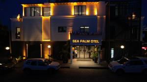 two cars parked in front of a building at night at Sea Palm Otel Yalıkavak in Yalıkavak