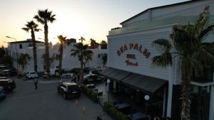 a street with cars parked in front of a building at Sea Palm Otel Yalıkavak in Yalıkavak