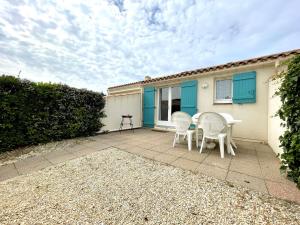 eine Terrasse mit zwei Stühlen und einem Tisch in der Unterkunft Maison T2 mezzanine avec piscine, à 200m de la mer, Bretignolles-sur-Mer - FR-1-224A-54 in Brétignolles-sur-Mer