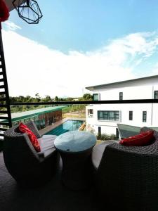 a patio with a table and chairs and a pool at Jeff and Ricky Homestay @ Forest Hill in Kuching
