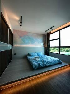Bett in einem Zimmer mit einem großen Fenster in der Unterkunft Jeff and Ricky Homestay @ Forest Hill in Kuching