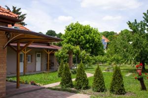 una casa con un jardín con árboles y arbustos en Ilona Apartman, en Gyula