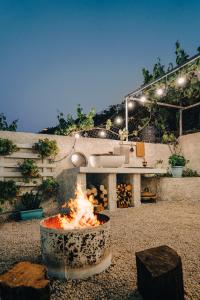 een vuurplaats in een tuin met een bad bij Patio Rooms Gjirokaster in Gjirokastër