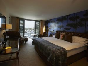 a woman laying on a bed in a hotel room at Salthouse Harbour Hotel and Spa in Ipswich