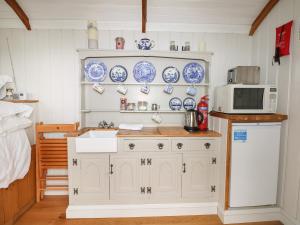 ルイスにあるShepherds Hutの- 壁に青と白の料理を用意したキッチン