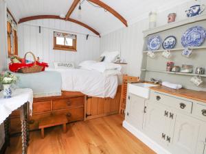 a bedroom with a bed and a sink in it at Shepherds Hut in Lewes