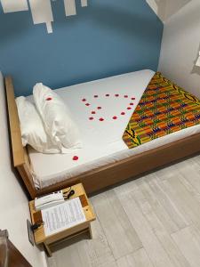 una cama con corazones rojos en ella con una mesa en Theo Good Life Hotel, en Big Ada