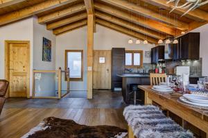 a kitchen and living room with wooden ceilings and a table at Chalet Gentiane in La Tzoumaz +19 photos