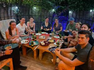 a group of people sitting around a table eating at Theo Good Life Hotel in Big Ada