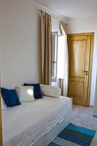 a bedroom with a bed with blue pillows and a door at Apartment Casa Beatrice in Pizzo