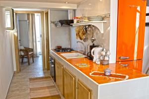 cocina con encimera y nevera de color naranja en Apartment Casa Beatrice, en Pizzo