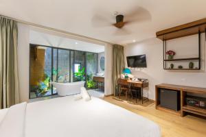 a bedroom with a large bed with a tub and a desk at Seaforest Hotel by Haviland in Da Nang