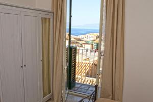 a room with a balcony with a view of a city at Apartment Casa Beatrice in Pizzo