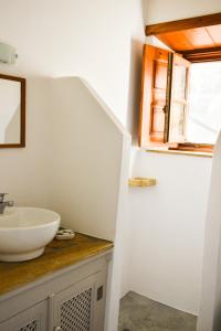 een badkamer met een wastafel en een raam bij Apartment Nektarios in Grikos