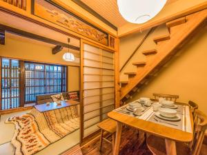 京都慶有魚•清水（Kyotofish·Kiyomizu）日式庭院浴缸三室町屋近清水寺的一间带桌子和楼梯的用餐室 更多23张照片