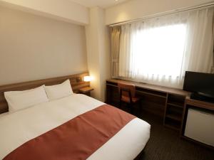 a hotel room with a bed and a window at Tokyo Inn in Tokyo