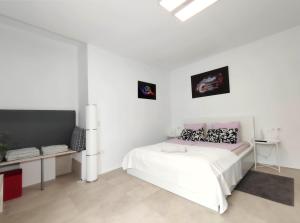 um quarto branco com uma cama e uma secretária em Apartment Fantastico 3 in Puerto de la Cruz Teneriffa em Puerto de la Cruz