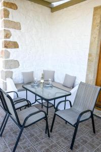 Apartment Nektarios في Grikos: طاولة وكراسي في فناء مع أريكة